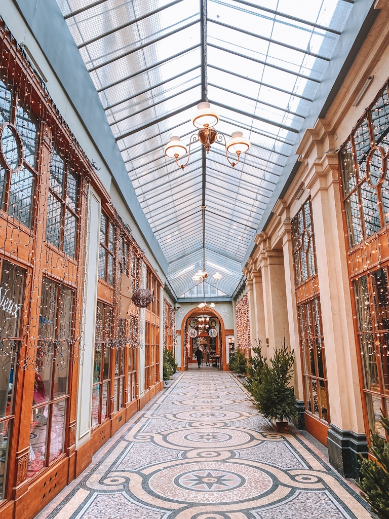 Galerie Vivienne à Paris décorée pour Noël avec mosaïques, verrière et vitrines scintillantes.