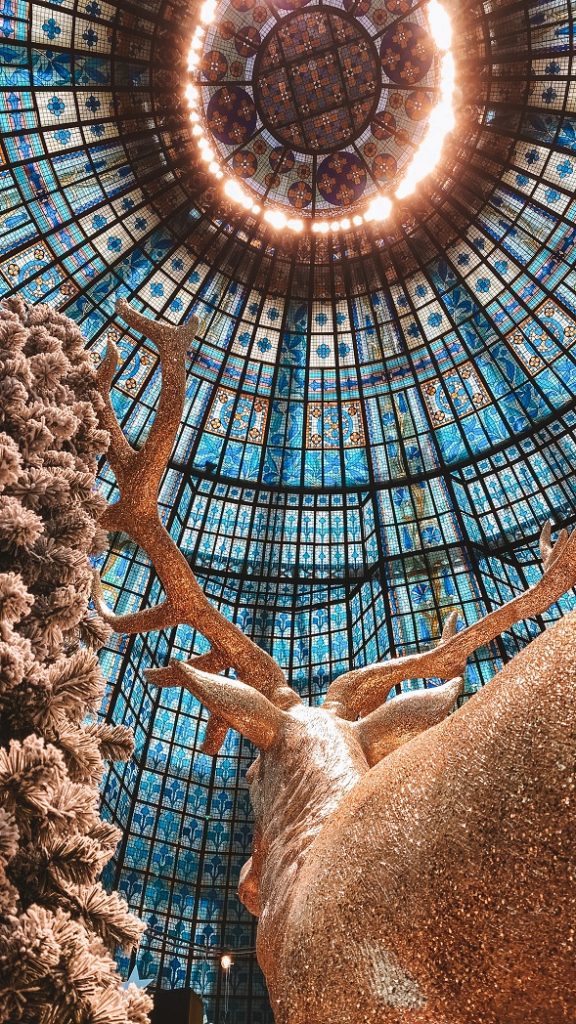 Cerf doré décoratif sous la coupole du Printemps Haussmann à Paris, un incontournable pour voir les illuminations de Noël Paris