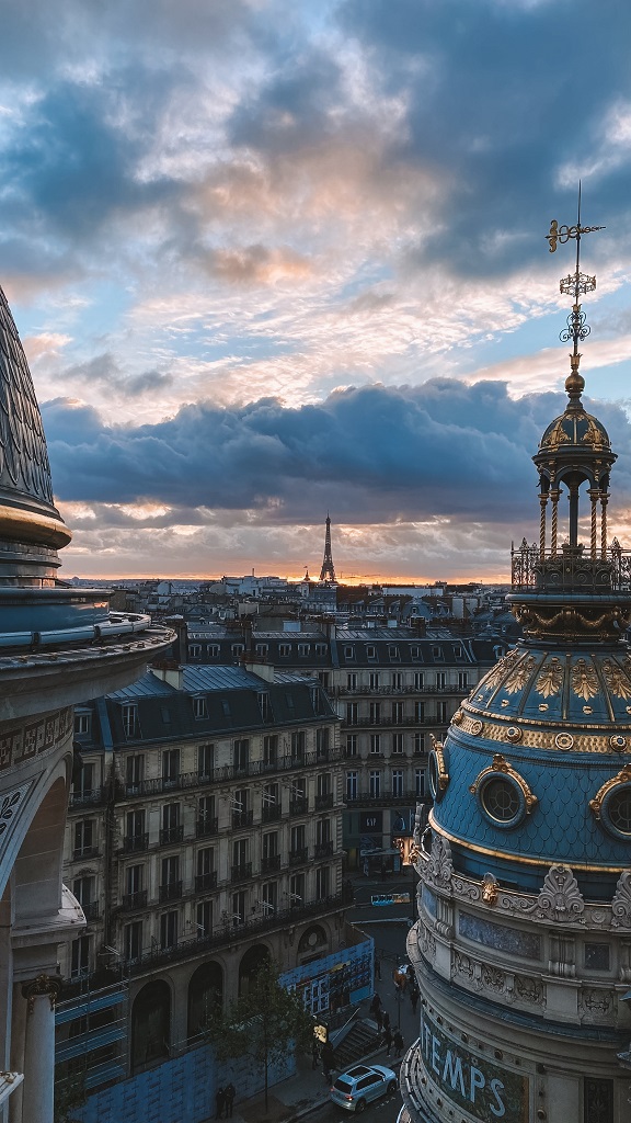 Ambiance féérique de Noël à Paris avec coucher de soleil et vue depuis le rooftop du Printemps Haussmann.
