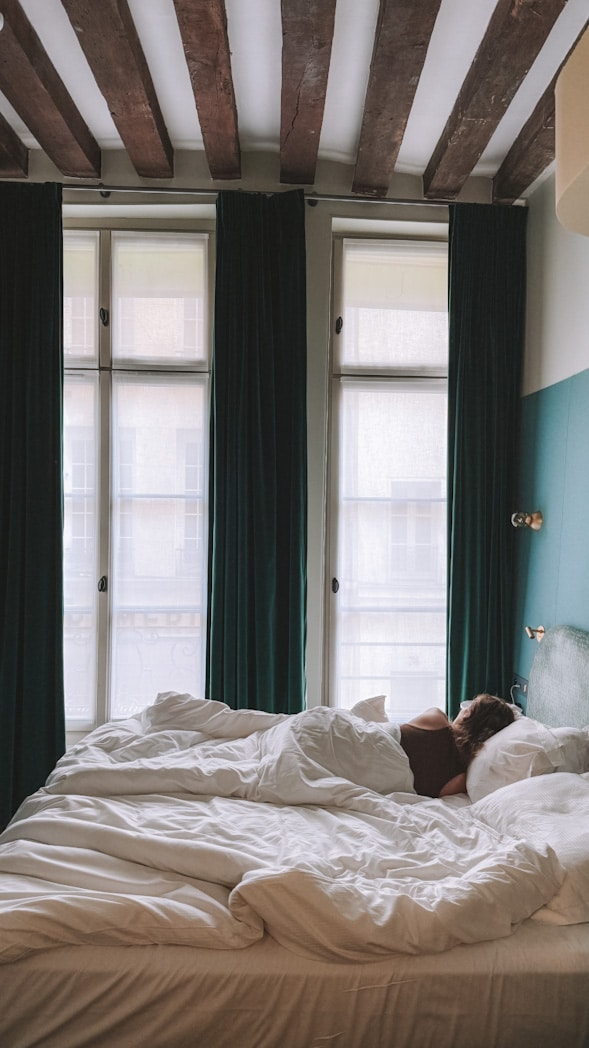 Chambre cosy avec poutres apparentes à l’Hôtel L de Lutèce de Paris sur l'Île Saint-Louis