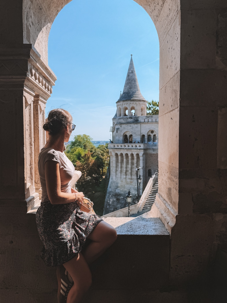 Vue sur le Bastion des Pêcheurs à Budapest encadrée par une arche en pierre