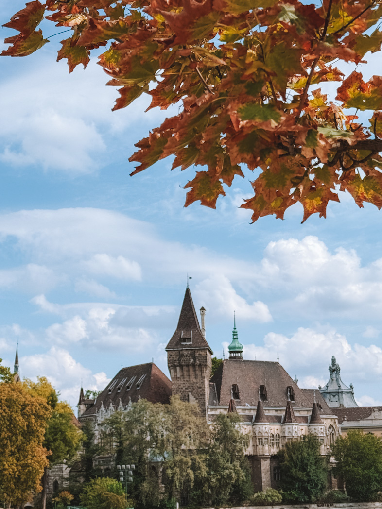 Château de Vajdahunyad à Budapest entouré de feuilles aux couleurs d’automne