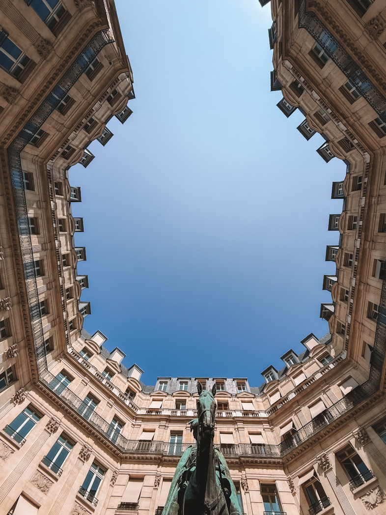 Perspective du ciel et des bâtiments sur la Place Edouard VII lors d'un itinéraire à pied dans le 9ème arrondissement de Paris