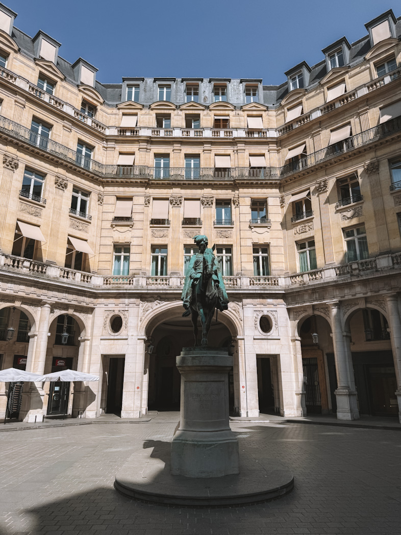 Statues et bâtiments haussmanniens de la Place Edouard VII lors d'une balade à pied dans le 9ème arrondissement de Paris