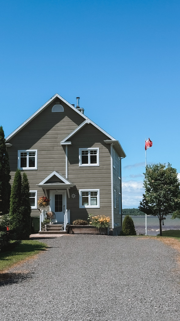 Maison avec drapeau canadien sur la route 132 longeant le fleuve Saint-Laurent