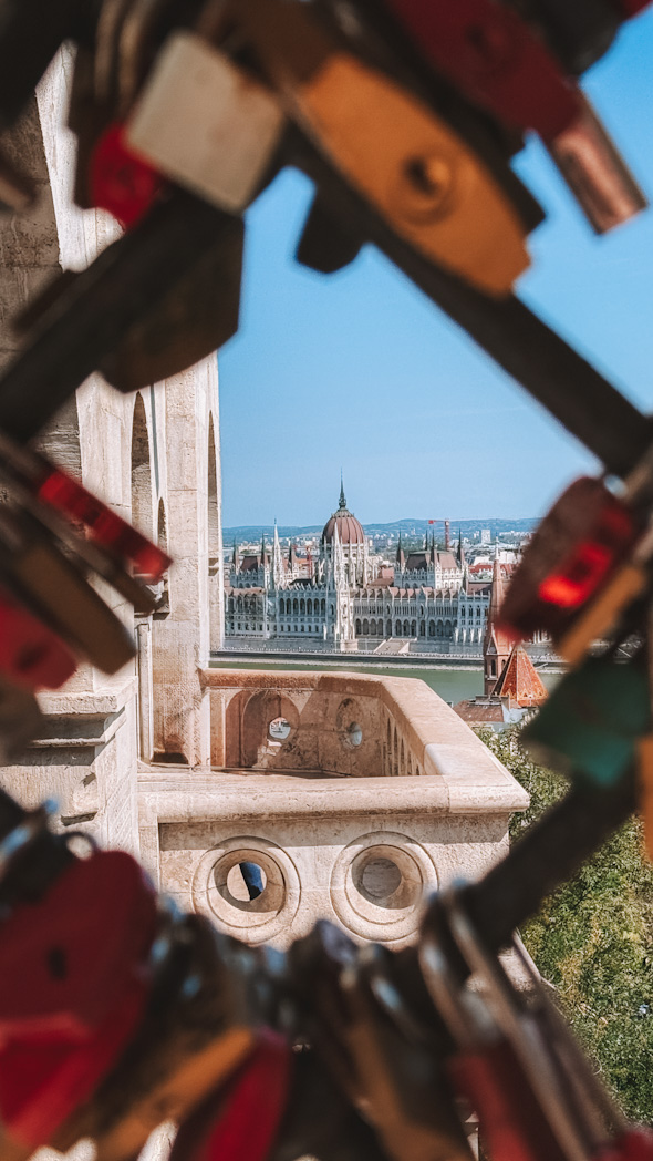 Vue sur le Parlement de Budapest depuis le Bastion des Pêcheurs encadrée par des cadenas