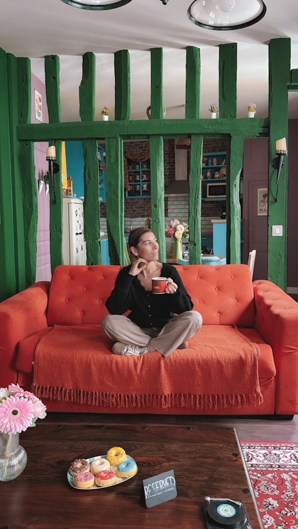 Intérieur d’un appartement Airbnb à Rouen décoré dans l’univers de la série Friends, avec mobilier vintage, couleurs vives et ambiance conviviale typique de Central Perk.