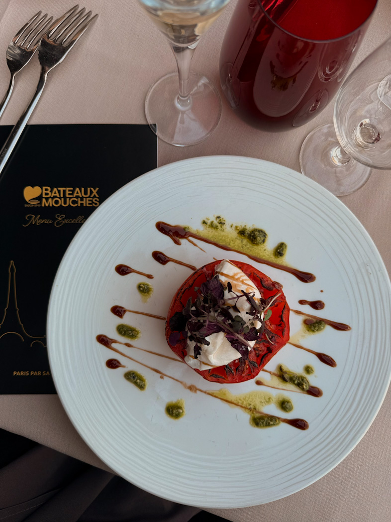 Plat gastronomique servi lors d'un dîner-croisière sur la Seine avec vue sur la Tour Eiffel illuminée à Paris