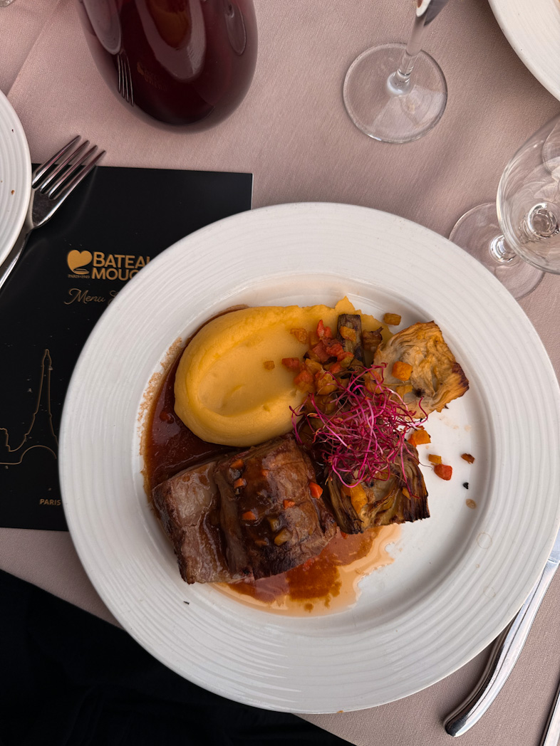 Plat gastronomique servi lors d'un dîner-croisière sur la Seine avec vue sur la Tour Eiffel illuminée à Paris